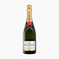 En flaske Moët & Chandon Impérial Brut Champagne med guldfolieret hals og den karakteristiske sorte etiket står oprejst på en hvid baggrund.